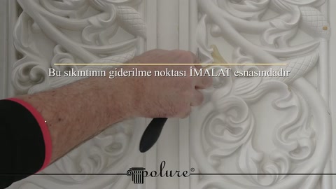 La mano esamina da vicino la verniciatura e i passaggi dei disegni nel pannello con motivi