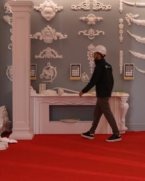 L'operaio si allontana dalla mostra del camino che mostra decorazione a colonne scanalate.