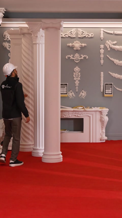 Craftsman leans against a column beside an ornate fireplace mantel.