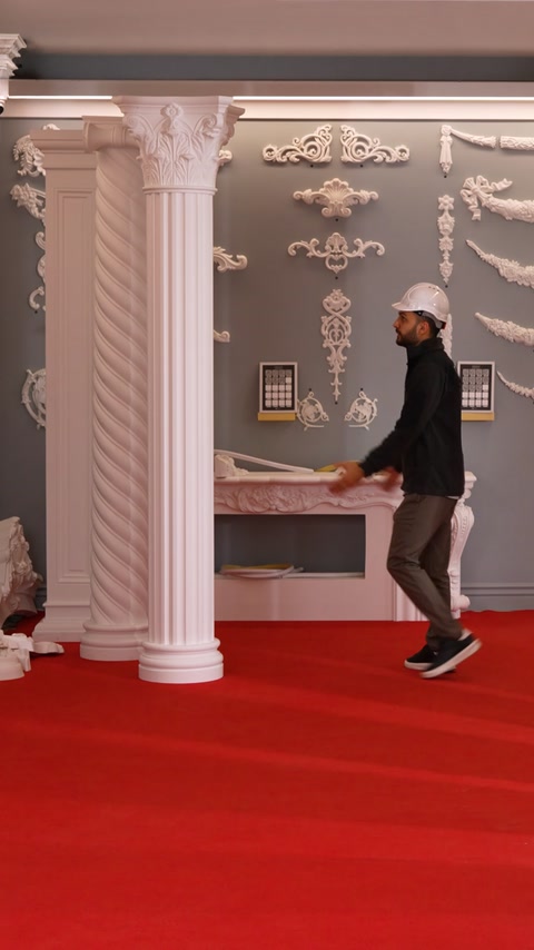 Worker crouches near a fireplace mantel with fluted column nearby.