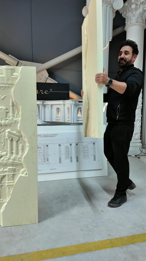 Usta uzun rölyef panelini tutarak ön yüzünü izleyiciye çeviriyor.