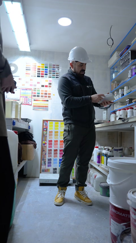 Üretim sorumlusu hazırlanan numune kabını laboratuvarda ekibe gösteriyor