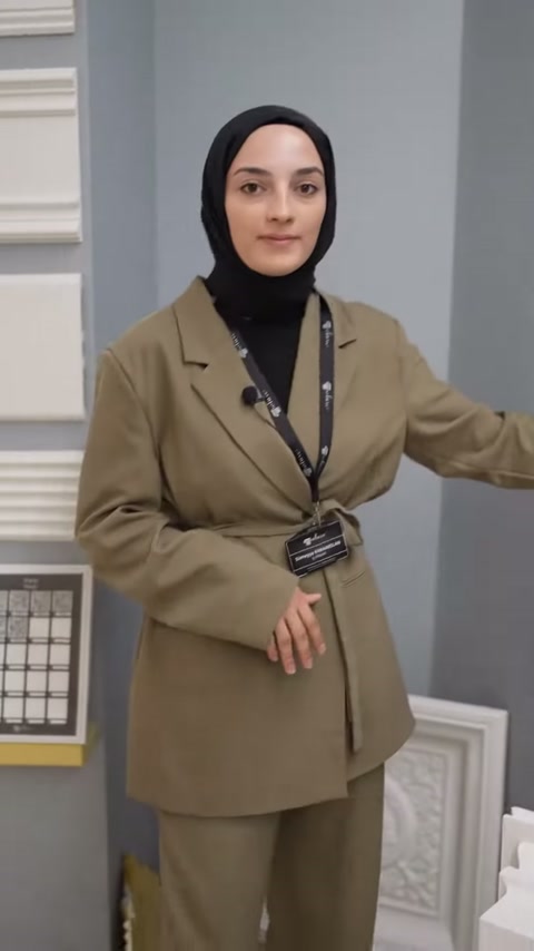 Sunucu showroomdaki çıta panellerinin yanında ürünleri tanıtmaya başlıyor.