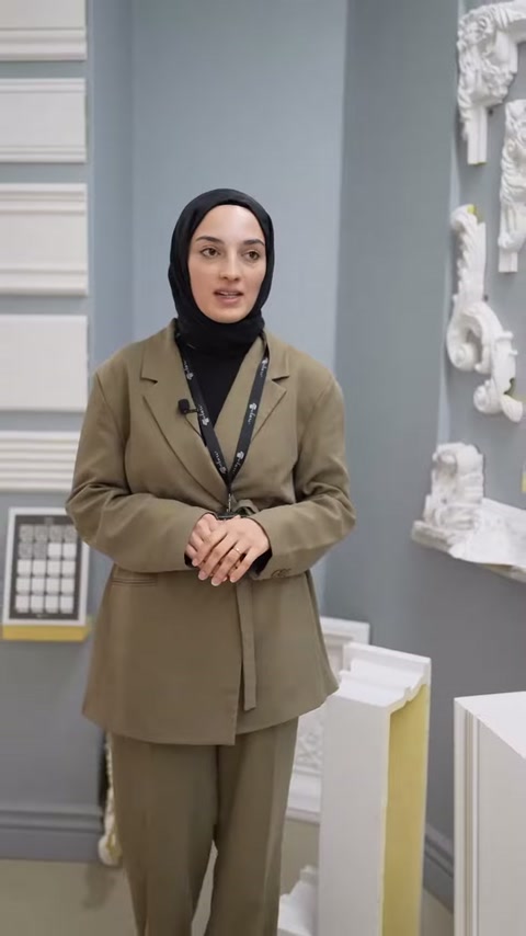 Duvar çıtaları ve kabartmalı paneller arasında ürün tanıtımı yapılıyor.