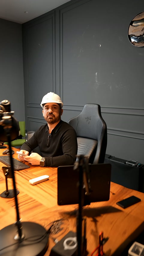 An expert in a beret discusses decoration designs on camera in the office.