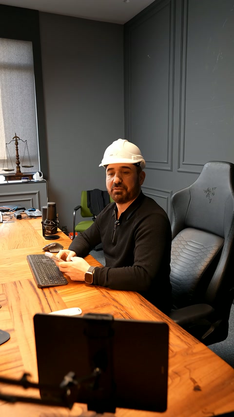 An expert talks about an exterior facade project at the desk.