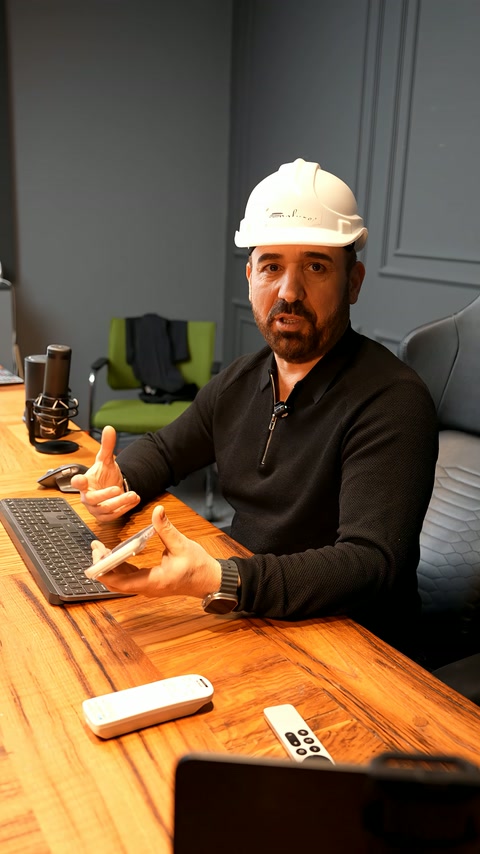 A presenter explains exterior facade design while examining the phone screen.