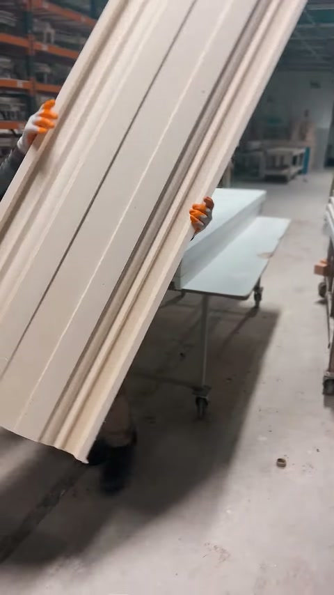 Profili in poliuretano per cornici trasportati verticalmente nel laboratorio di produzione