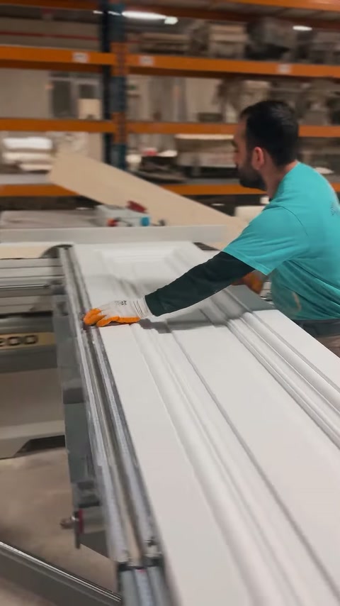 Finitura bianca in poliuretano allineata su banco con guide metalliche per la produzione