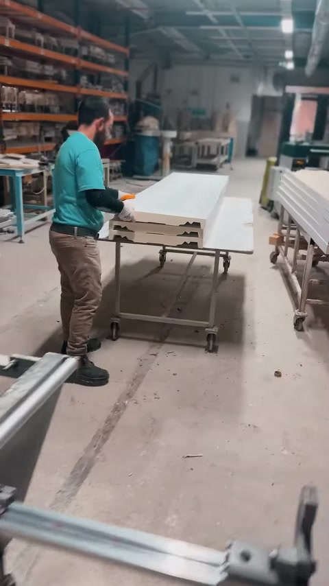 Lunghi profili in poliuretano trasportati su carrello a ruote nel laboratorio