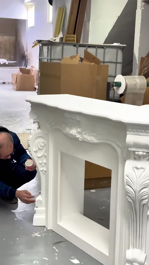 Vengono controllati i dettagli della superficie del camino decorativo bianco completato