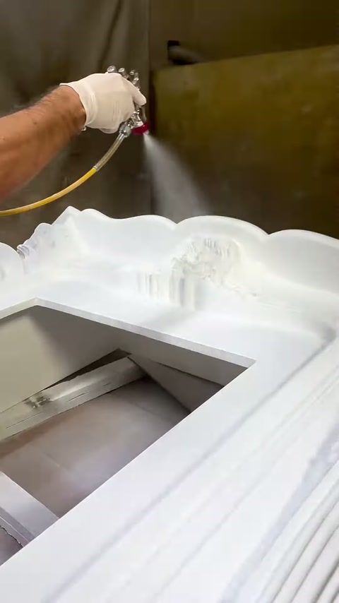 La pistola a spruzzo applica vernice alla sezione superiore ondulata del camino
