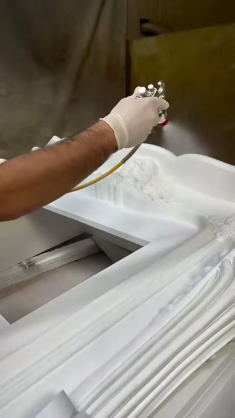 La pistola a spruzzo scorre lungo il bordo superiore decorativo del camino