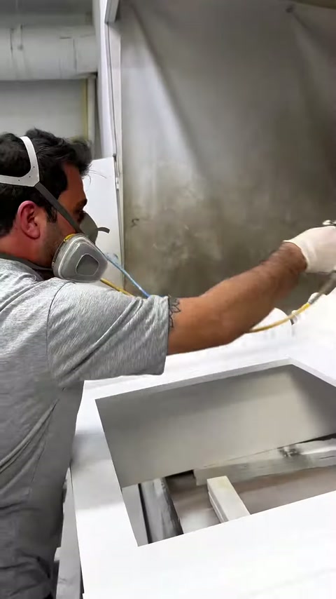 L'operaio mascherato spruzza il corpo orizzontale del camino in laboratorio