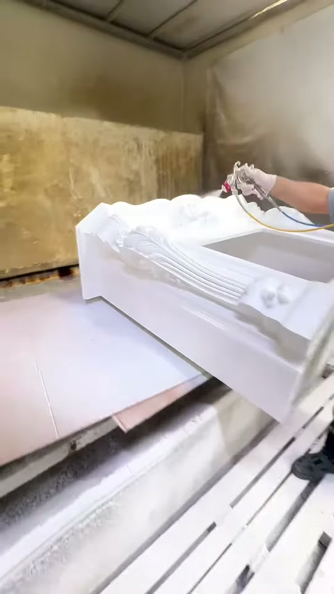 La cornice del camino posizionata orizzontalmente viene trattata nella cabina di verniciatura