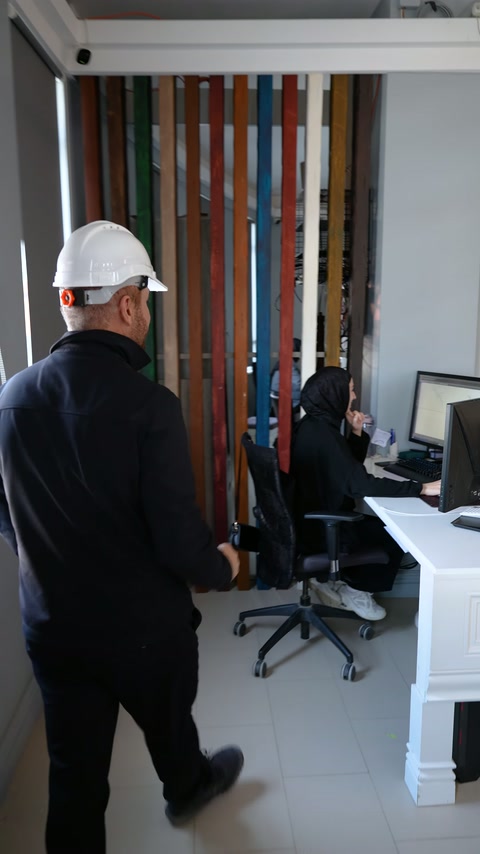 Baretli çalışan profil tasarımının yapılacağı masaüstü bilgisayara yöneliyor