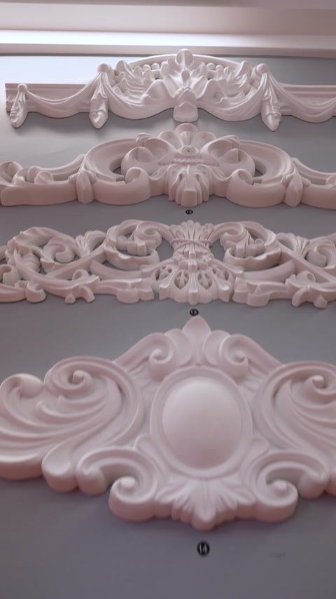 Appliques da parete in rilievo di diverse forme sono esposte ordinatamente.