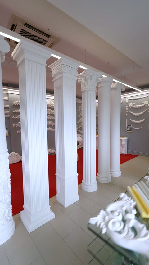 Geniş showroom alanında kare ve yuvarlak gövdeli sütun dizisi görülüyor.