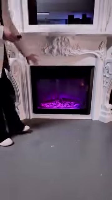 Un inserto con effetto fiamma viola è esposto con una cornice decorata con motivi floreali in rilievo