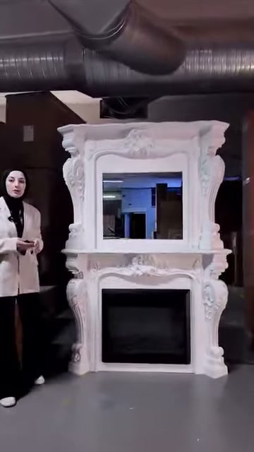 L'architrave in rilievo e i piedi ondulati completano il design del camino