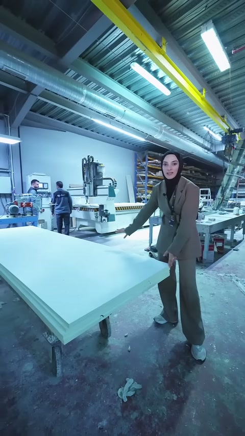 Il server indica con la mano la lunga superficie del pannello sul banco dell'officina