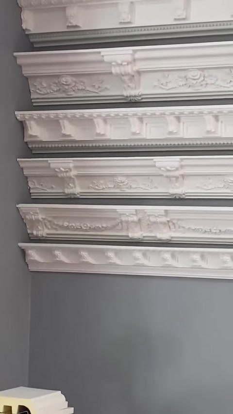 Modelli di modanature classiche e bordure in rilievo disposti su una parete