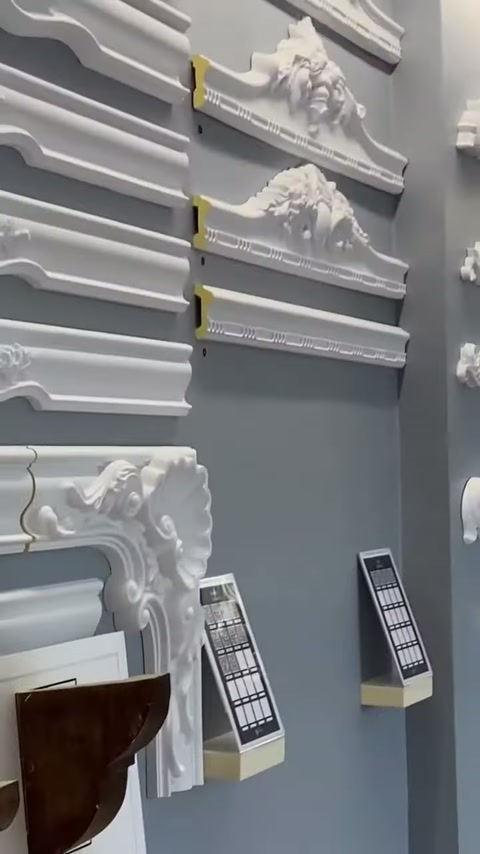 Su un pannello murale sono allineate cornici piatte e bordure con vari rilievi decorativi.