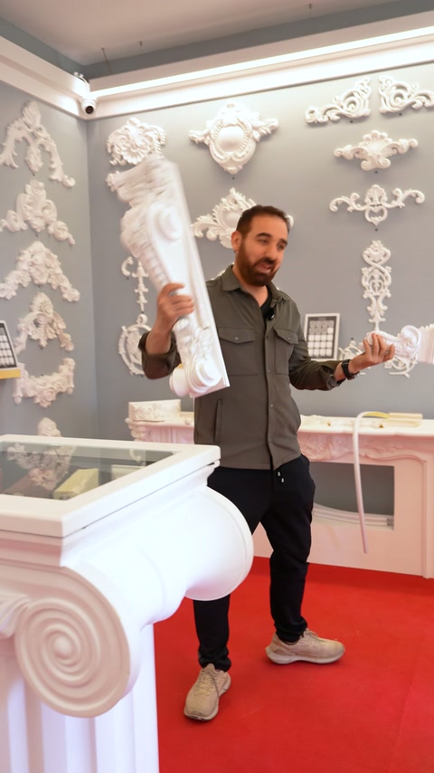 Baluster models are examined by hand in showroom with decorative columns