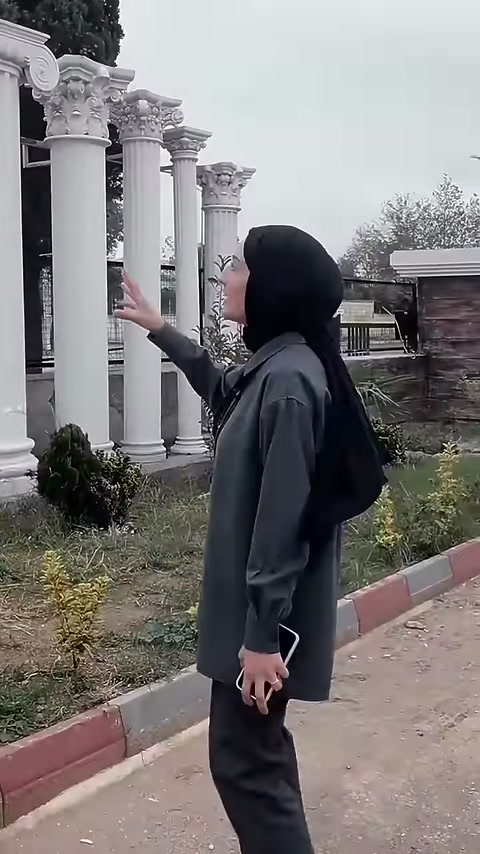 The presenter explains product details in front of plain columns with bases.
