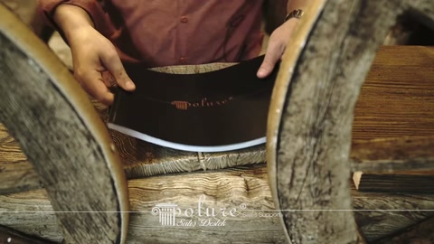 A dark-colored catalog cover is opened in front of wood-textured samples.