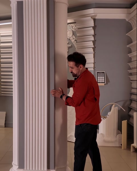 Narrow fluted pilaster shaft mounted flat against grey showroom wall
