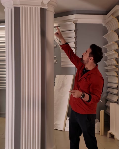 Hand pointing up to plain capital joining the continuous moulding band