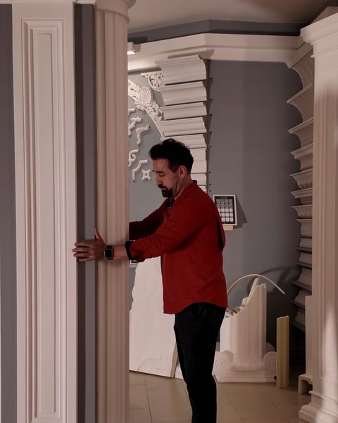 Presenter holding half of a fluted round column against the wall