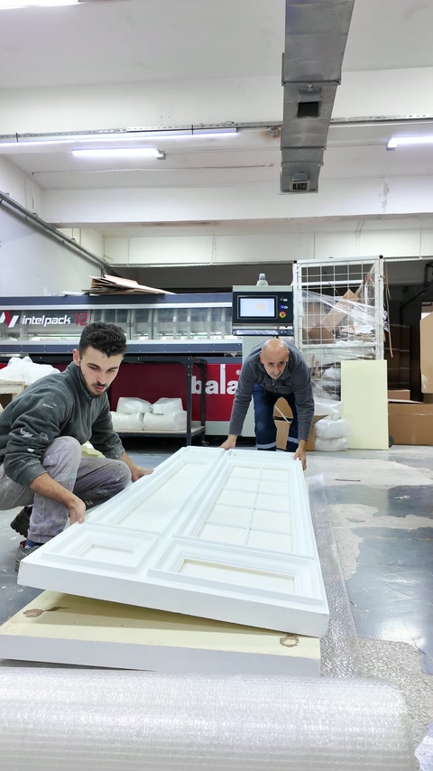 Gli operai iniziano ad avvolgere il pannello decorativo finito per proteggerlo