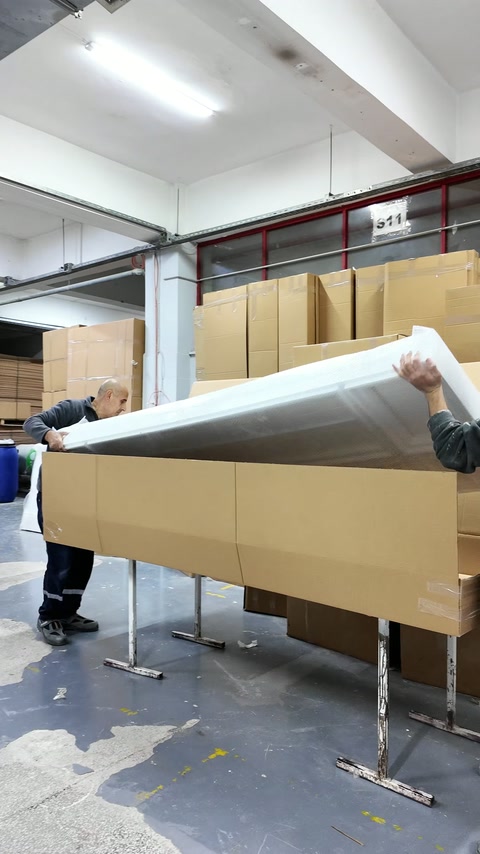 Il pannello in poliuretano avvolto viene calato con cura in un cartone per la spedizione