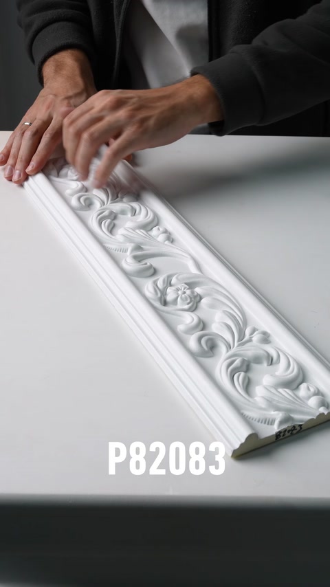 Mani che scorrono lungo un pannello di fregio murale decorativo in poliuretano