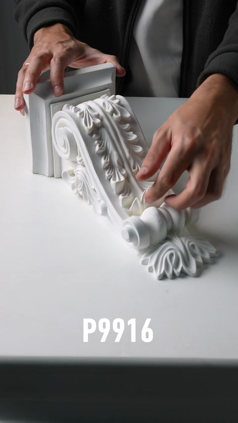 Mano che tocca una consolle in poliuretano con scultura a motivi e rosone