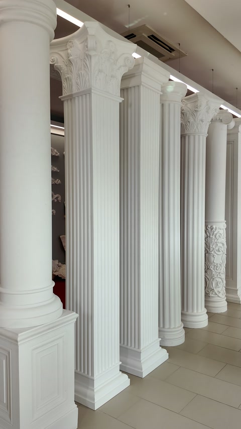 White classical columns with fluted shafts displayed across the showroom