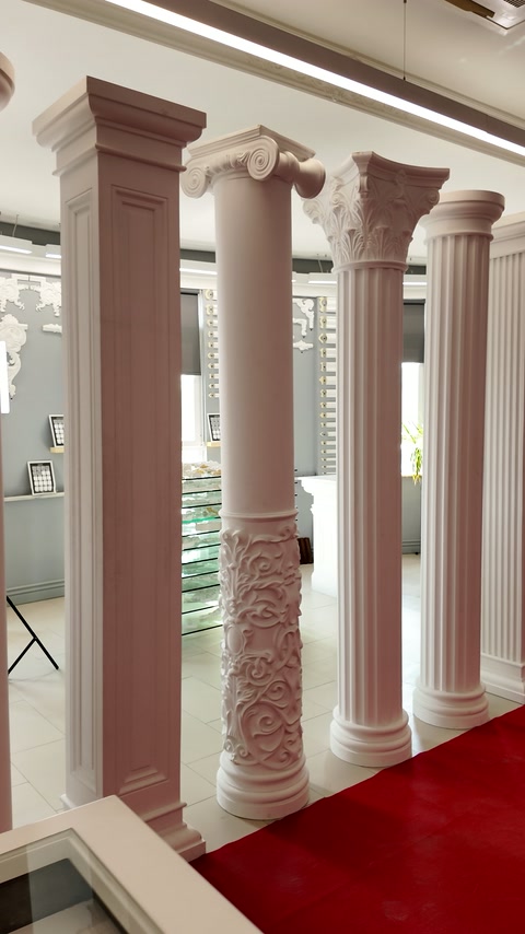 Varied round and square columns arranged beside a red carpet