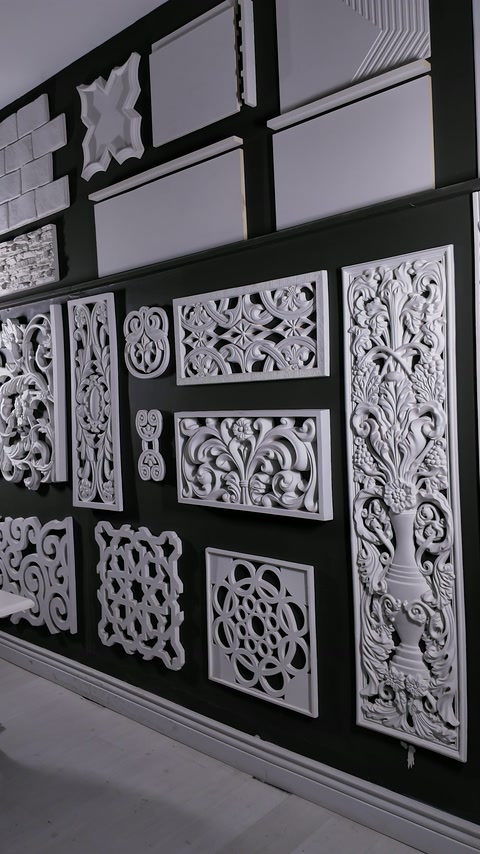 Decorative relief panels and ornamental profiles mounted on a dark wall