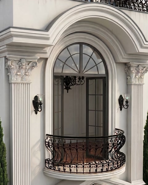 Arched entrance surround combines fluted pilasters, moldings, and decorative capitals.