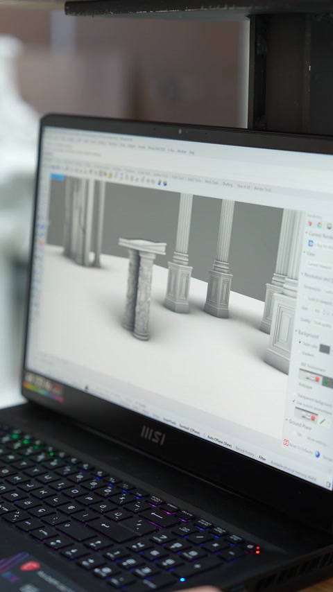 Sul monitor di un computer è visibile un progetto 3D composto da colonne e capitelli