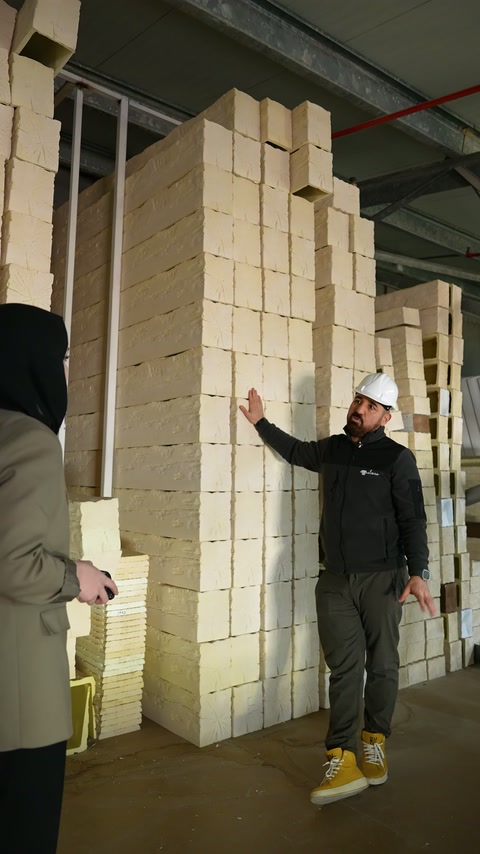 Depo alanında çalışan istiflenmiş hammadde bloklarını kontrol ediyor