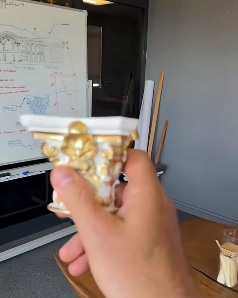 Il campione del capitello viene confrontato davanti a un disegno tecnico della facciata