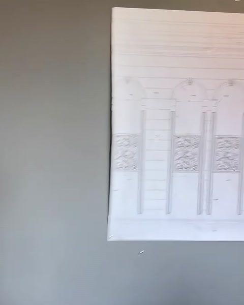 Una tavola di progetto stampata con opzioni di colonne decorative è esposta sulla parete