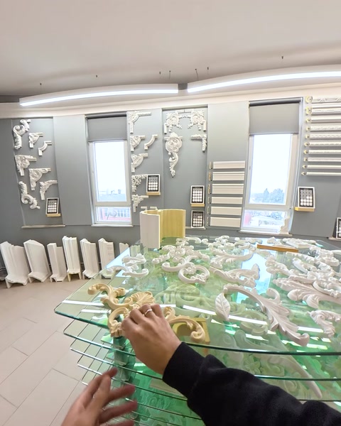 Glass display table showcasing multiple relief molding samples
