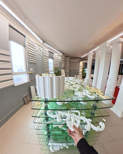 Glass table filled with layered relief molding pieces