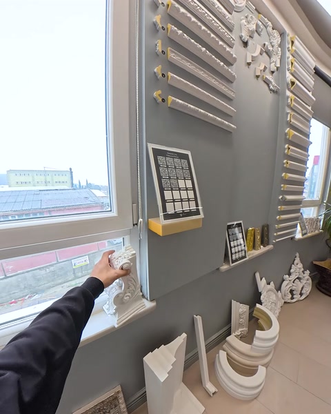 Hand reaching toward window ledge with molding samples