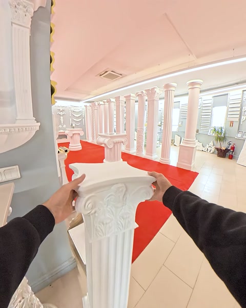 Hand holding ornate capital piece near column top