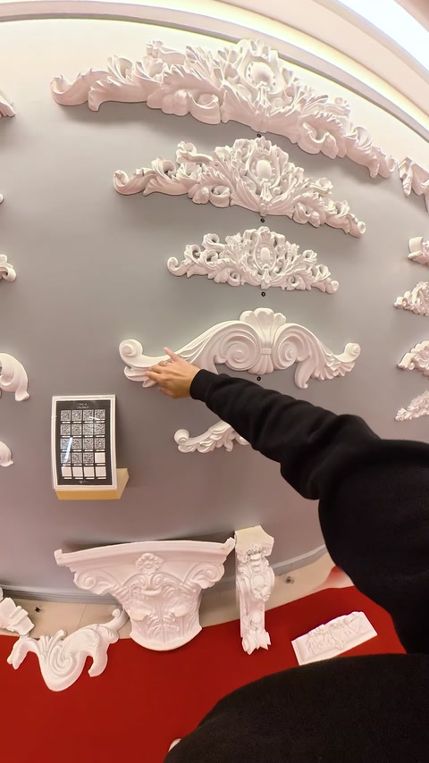 Mano che monta un'applique decorativa su un pannello murale dello showroom